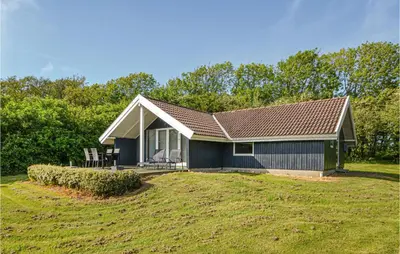 a small blue house on a grassy field at Holiday Home Gunhildsvej Vestervig in Vestervig