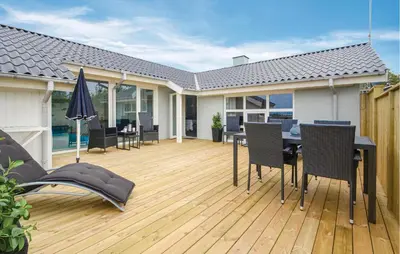 a deck with a table and chairs on a house at Awesome Home In Vestervig With Kitchen in Vestervig