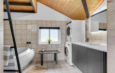 a bathroom with a tub sink and a washing machine at Holiday Home Gunhildsvej Vestervig Vi in Vestervig
