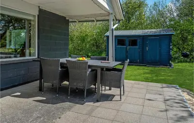 a table and chairs on a patio with a house at Holiday Home Gunhildsvej Vestervig Xii in Vestervig