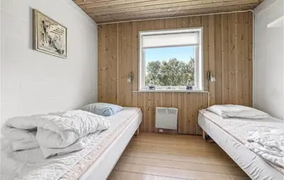 two beds in a room with a window at Holiday Home Gunhildsvej Vestervig Xii in Vestervig