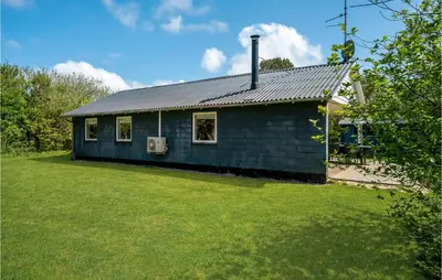 a blue house with a grass yard at Holiday Home Gunhildsvej Vestervig Xii in Vestervig