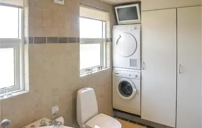 a bathroom with a washing machine and a toilet at Holiday Home Strandlyst Vinderup Vi in Vinderup