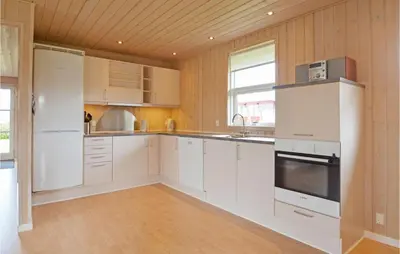 a kitchen with white appliances and a wooden ceiling at Holiday Home Strandlyst Vinderup Vi in Vinderup