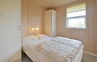 a bedroom with a large bed with a window at Holiday Home Strandlyst Vinderup Vi in Vinderup