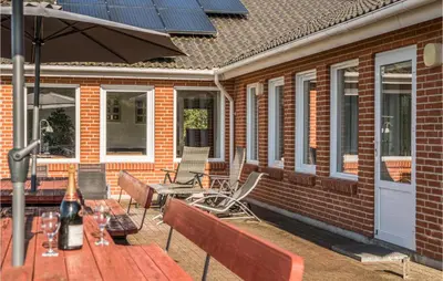 a patio with a table and chairs with solar panels on it at Stunning Home In Spøttrup With Sauna in Spottrup