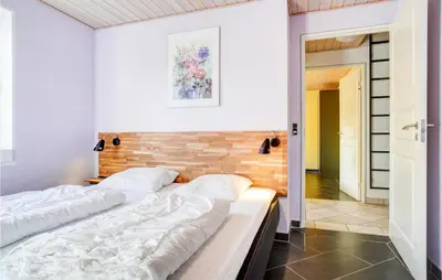 two beds in a bedroom with a wooden headboard at Stunning Home In Spøttrup With Sauna in Spottrup