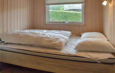 two pillows on a bed in a room with a window at Holiday Home Skovstjernevej Lemvig Ii in Lemvig