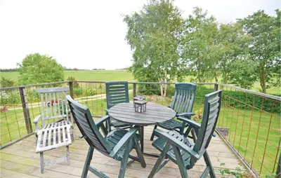 a wooden table and four chairs on a deck at Apartment Lysenvej in Roslev