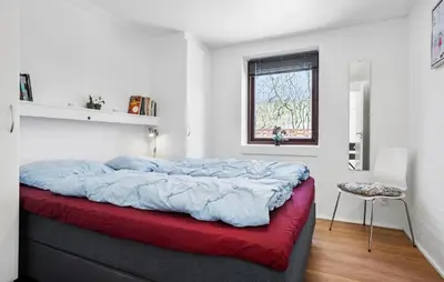 a bedroom with a large bed with a red blanket at Amazing Home In Vinderup With Sauna in Vinderup