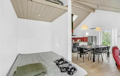a bedroom and a dining room with a bed and a table at Holiday Home Skovvej Thyholm Xii in Thyholm