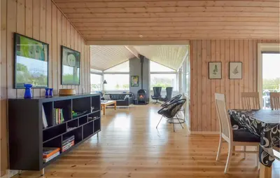 a living room with a table and a dining room at Holiday Home Kalkstensvej in Spottrup
