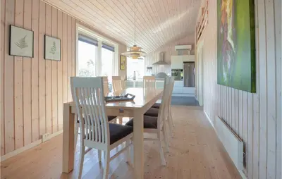 a dining room with a wooden table and chairs at Holiday Home Kalkstensvej in Spottrup