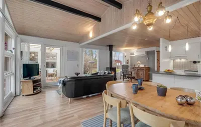 a kitchen and a living room with a table at Holiday Home Hærvej Thyholm Xi in Thyholm
