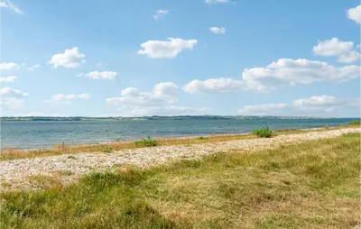 a sandy beach with the ocean in the background at Strandbo in Thyholm