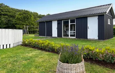 a black and white shed in a yard at Holiday Home Strandlyst Vinderup I in Vinderup