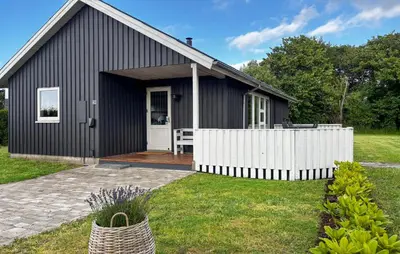a black house with a white fence in front of it at Holiday Home Strandlyst Vinderup I in Vinderup