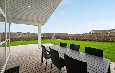 a wooden deck with a table and chairs on it at Holiday Home Kildebakken Vinderup V in Vinderup