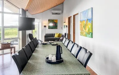 a dining room with a long table and chairs at Holiday Home Lerskrænten Vinderup Xi in Vinderup