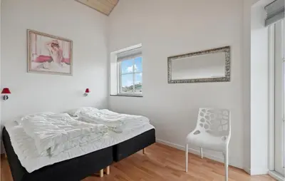 a bedroom with a bed and a chair in it at Holiday Home Lerskrænten Vinderup Xi in Vinderup