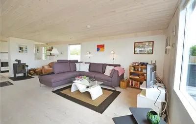 a living room with a purple couch and a tv at Holiday Home Lærkevej Vinderup Xii in Vinderup