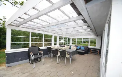 a pergola with a table and chairs on a patio at Holiday Home Lærkevej Vinderup Xii in Vinderup