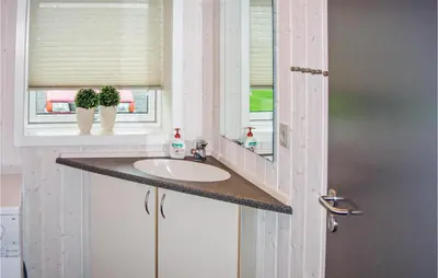 a bathroom with a sink and a mirror at Holiday Home Houmøllevej in Karby
