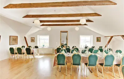 a room with a long table with green chairs at Bakkegården in Vesløs