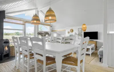 a white dining room with a white table and chairs at Holiday Home Ballesvej in Øster Assels
