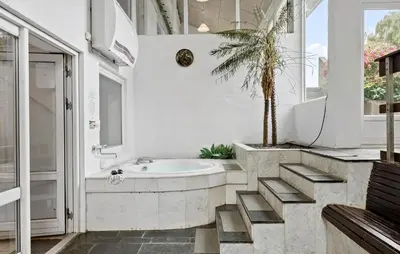 a bathroom with a tub and a palm tree at Stunning Home In Roslev With Sauna in Roslev
