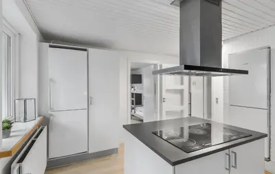 a kitchen with white cabinets and a black counter top at Stunning Home In Roslev With Sauna in Roslev