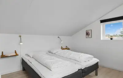 a bed in a white room with a window at Stunning Home In Roslev With Sauna in Roslev