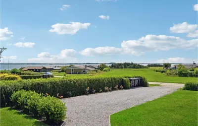 a gravel path through a garden with bushes at Holiday Home Limfjordsvangen Snedsted X in Snedsted