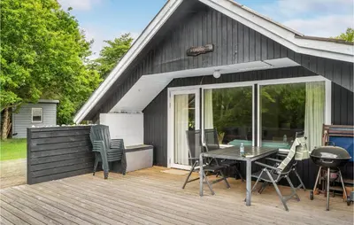 a patio with a table and chairs on a deck at Holiday Home Klydevej Hurup Thy Xi in Sindrup