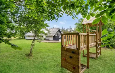 a wooden playground in a yard with a gazebo at Holiday Home Klydevej Hurup Thy Xi in Sindrup