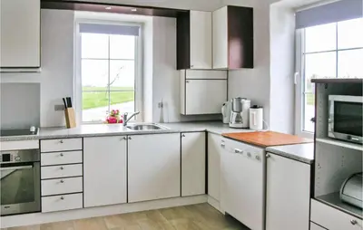 a kitchen with white cabinets and a sink at Holiday Home Bakkegårdsvej in Vesløs