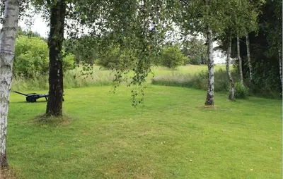 a park with trees and a bench in the grass at Holiday Home Kraghøjvej Nykøbing M Ix in Hesselbjerg