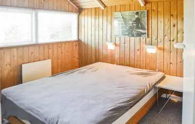 a bedroom with a bed in a wooden wall at Holiday Home Sulevej Hurup Thy Xi in Sindrup