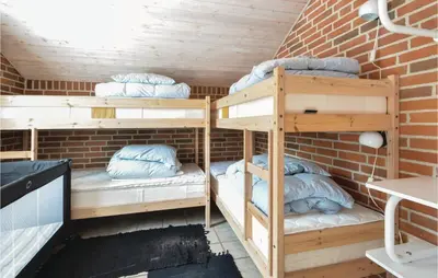 a room with bunk beds in a brick wall at Holiday Home Grynderup Strand Roslev in Roslev