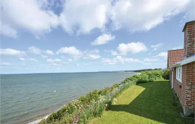 a view of the ocean from a house at Holiday Home Grynderup Strand Roslev in Roslev
