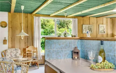 a kitchen with a table with a bottle of wine at Holiday Home Sølvmågevej Hurup Thy Ii in Sindrup