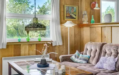 a living room with a couch and a table at Holiday Home Sølvmågevej Hurup Thy Ii in Sindrup