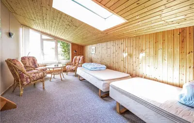 a room with two beds and chairs and a skylight at Holiday Home Limfjordsvangen Snedsted Vi in Snedsted