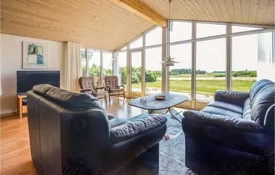 a living room with two couches and a table at Holiday Home Limfjordsvangen Snedsted Vi in Snedsted