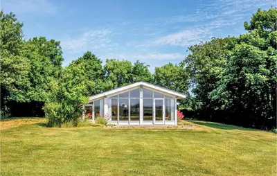 a glass house in a field with trees at Holiday Home Limfjordsvangen Snedsted Vi in Snedsted