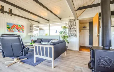 a living room with a couch and a chair and a stove at Nice Home In Thisted With Kitchen in Thisted