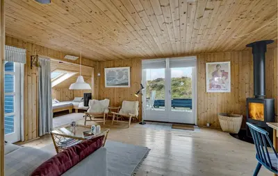 a living room with wooden walls and a wooden ceiling at Holiday Home Svenstibakkevej Ii in Frøstrup