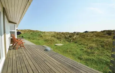 a porch of a house with a chair and a table at Holiday Home Svenstibakkevej I in Frøstrup