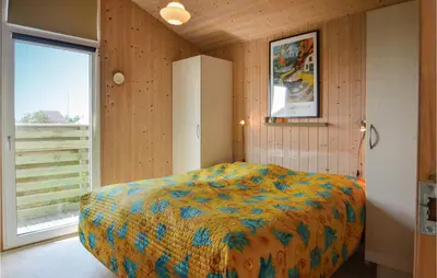 a bedroom with a bed and a large window at Holiday Home Svenstibakkevej I in Frøstrup