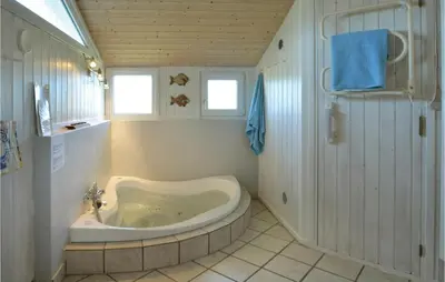 a bathroom with a tub in the corner at Holiday Home Svenstibakkevej I in Frøstrup